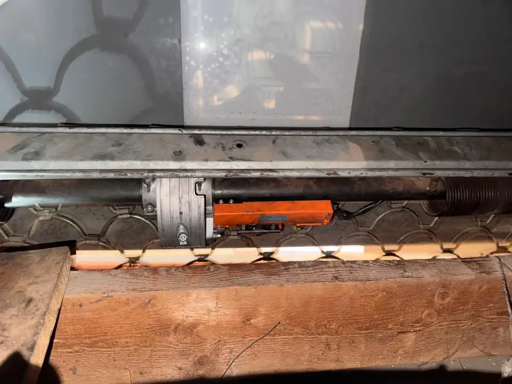Motor montado sobre el eje de un cierre de ballesta, visto desde abajo dentro del cajón